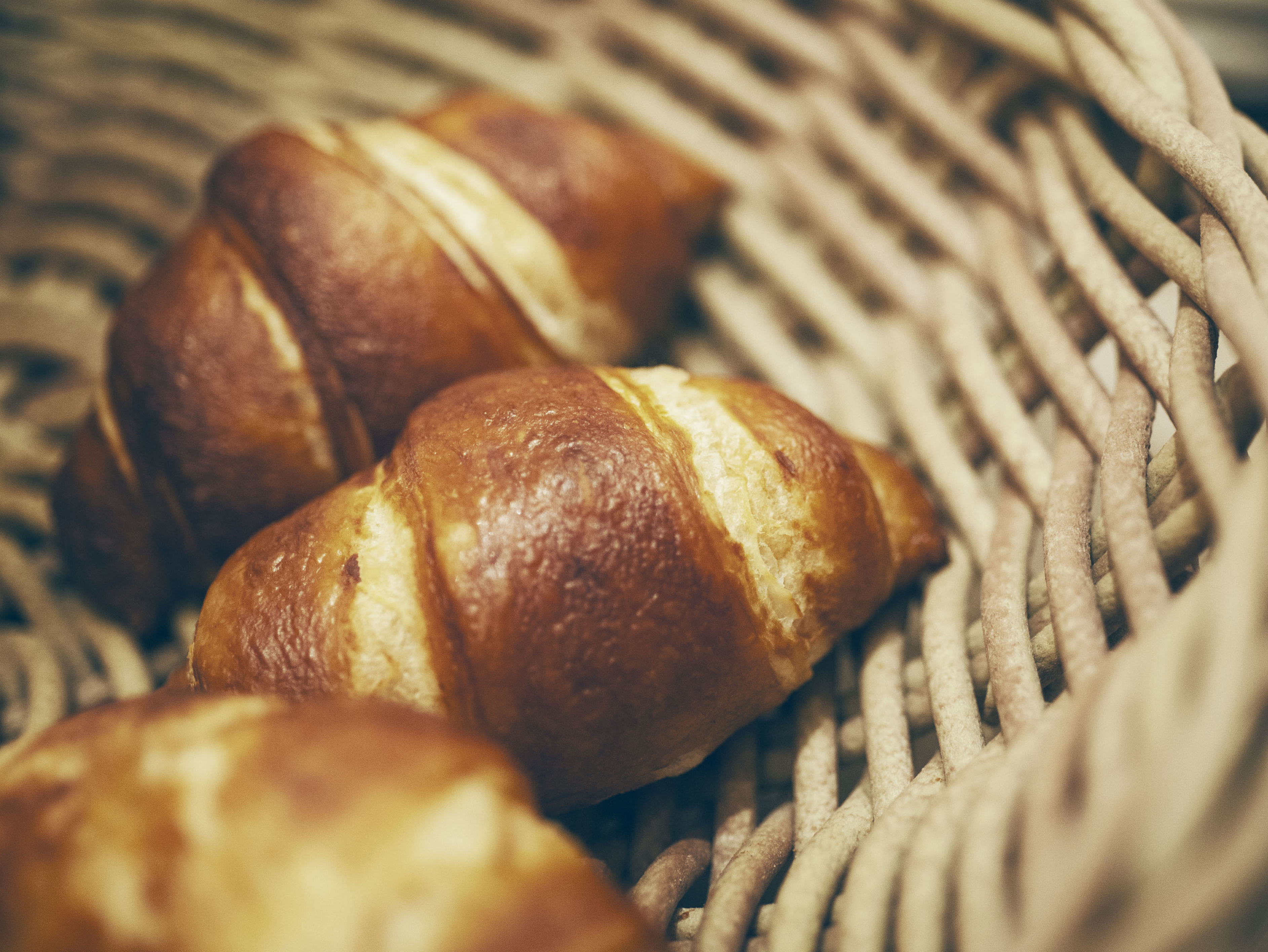 Laugen-Croissants im Korb Frische Laugen-Croissants in einem Weidenkorb