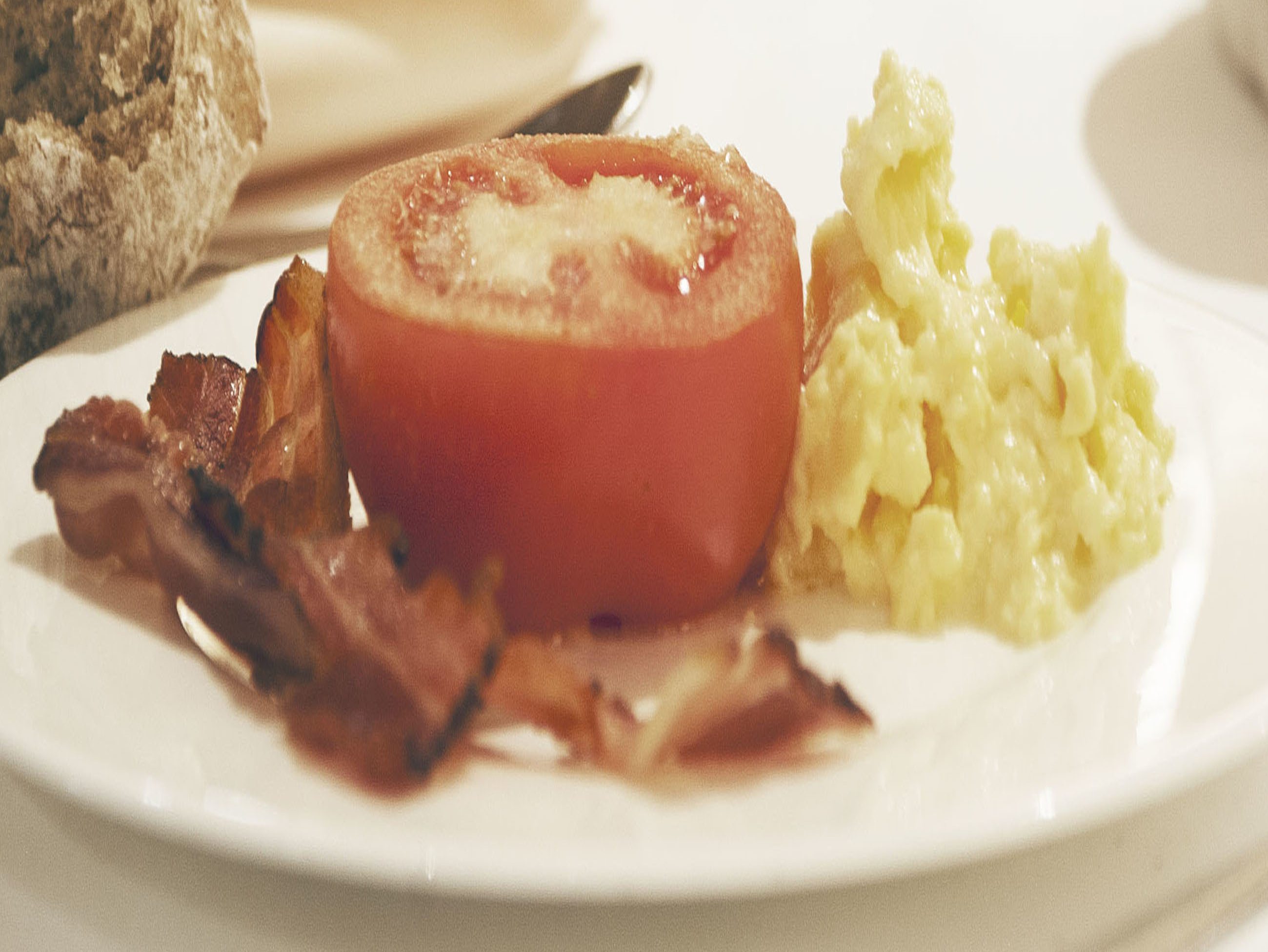 Leckeres Frühstück Frühstücksteller mit Ei, Speck und Tomate auf dem Tisch
